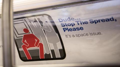 Ein Hinweisschild in der New Yorker U-Bahn untersagt Männern das breitbeinige Sitzen (9.2.2015).