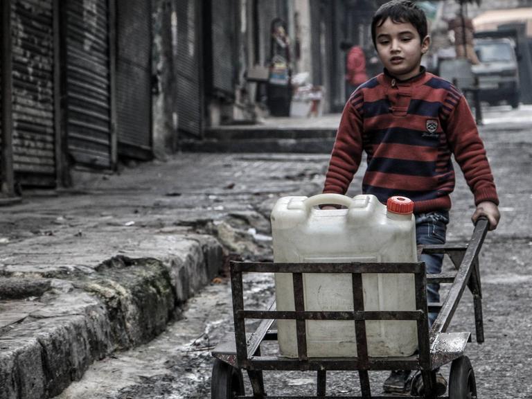 Ein Kind in Aleppo mit einem Wasserkanister