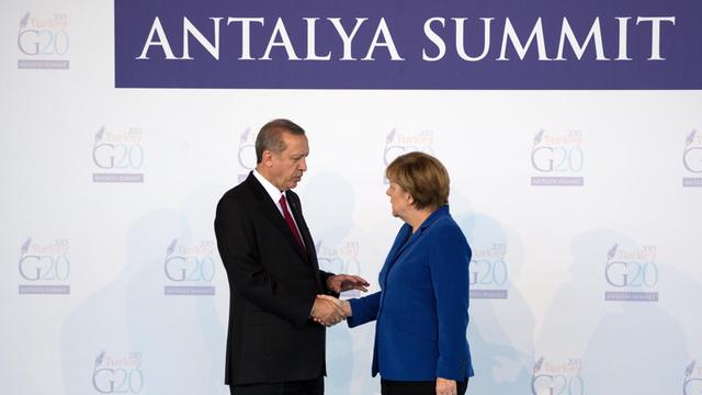 Der türkische Präsident Recep Tayyip Erdogan begrüßt am 15.11.2015 in Belek bei Antalya (Türkei) beim Gipfel der großen Industrie- und Schwellenländer (G20) Bundeskanzlerin Angela Merkel (CDU). Die Gruppe der G20, neunzehn Industrie- und Schwellenländer sowie die EU, tagt unter dem Vorsitz der Türkei am 15. und 16.11.2015 in dem türkischen Badeort.