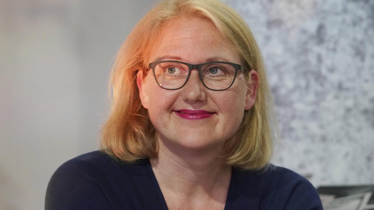 Lisa Paus sitzt auf einer Bühne und schaut freundlich ins nicht sichtbare Publikum. Lisa Paus sitzt auf einer Bühne und schaut freundlich ins nicht sichtbare Publikum.