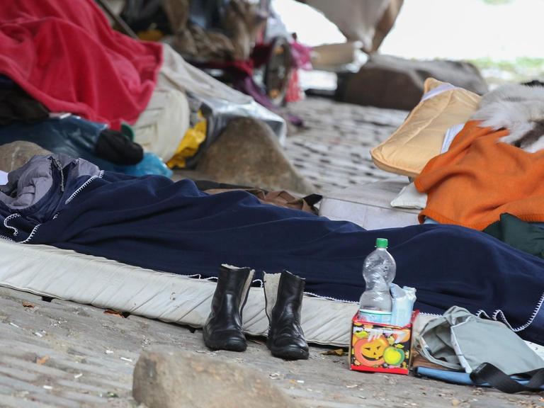 Ein Obdachloser hat sich im Freien in einen Schlafsack verkrochen. 