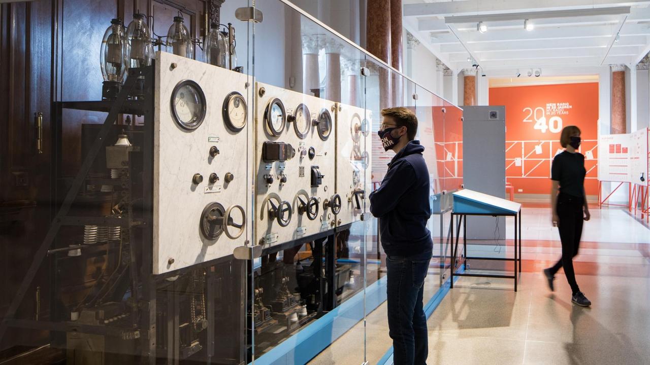 Ein Ausstellungsbesucher betrachtet ein Teil des Radiosenders, von dem am 22.12.1920 die erste Rundfunksendung in Deutschland ausgestrahlt wurde. Ein Ausstellungsbesucher betrachtet ein Teil des Radiosenders, von dem am 22.12.1920 die erste Rundfunksendung in Deutschland ausgestrahlt wurde.
