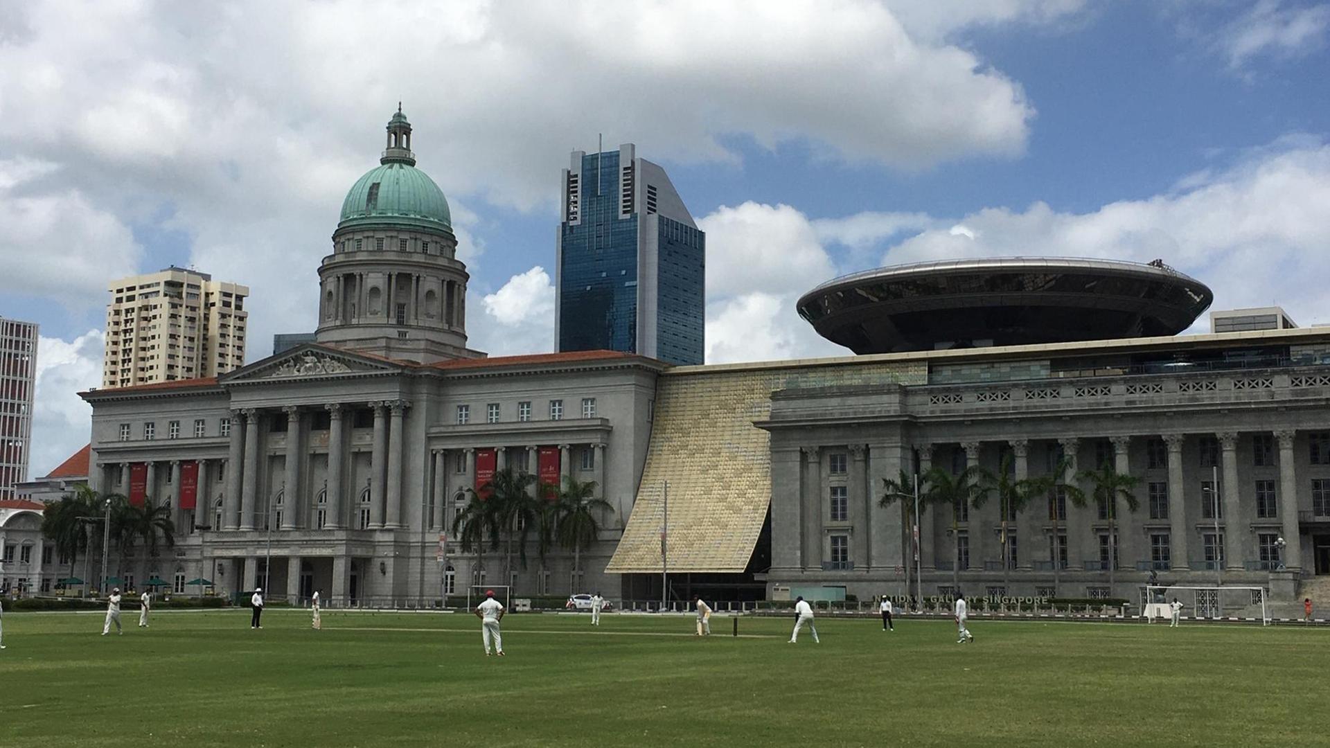 Cricket-Spieler vor der National Gallery in Singapur Cricket-Spieler vor der National Gallery in Singapur