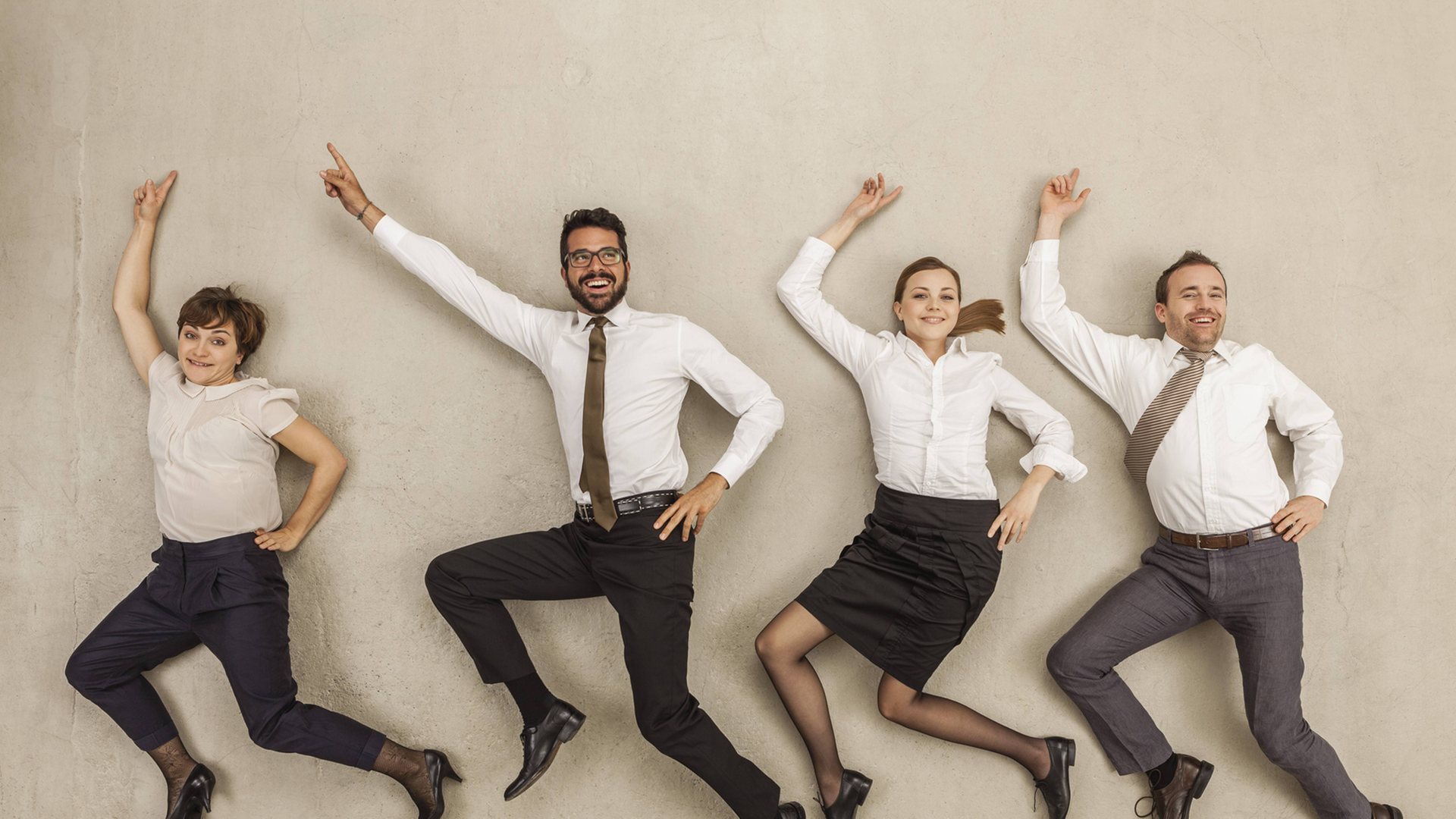 Menschen in Businesskleidung liegen auf dem Rücken, als würden sie durchs Büro tanzen Menschen in Businesskleidung liegen auf dem Rücken, als würden sie durchs Büro tanzen