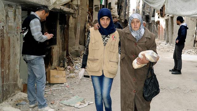 Ein Foto der staatlichen syrischen Nachrichtenagentur SANA zeigt Bewohner des palästinensischen Flüchtlingslagers Yarmouk in Damaskus.