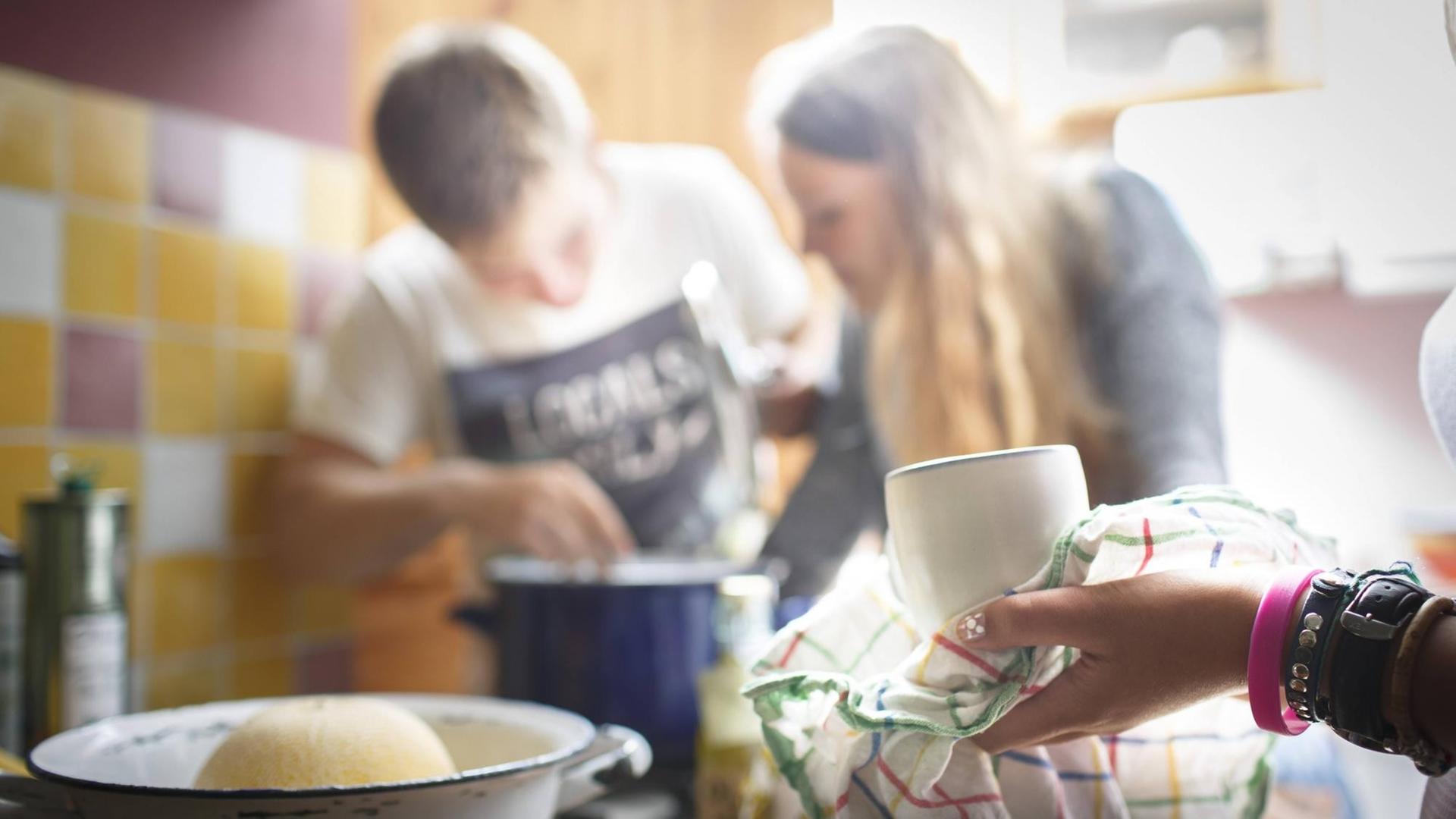 Zwei Studenten kochen zusammen in einer WG-Küche Zwei Studenten kochen zusammen in einer WG-Küche
