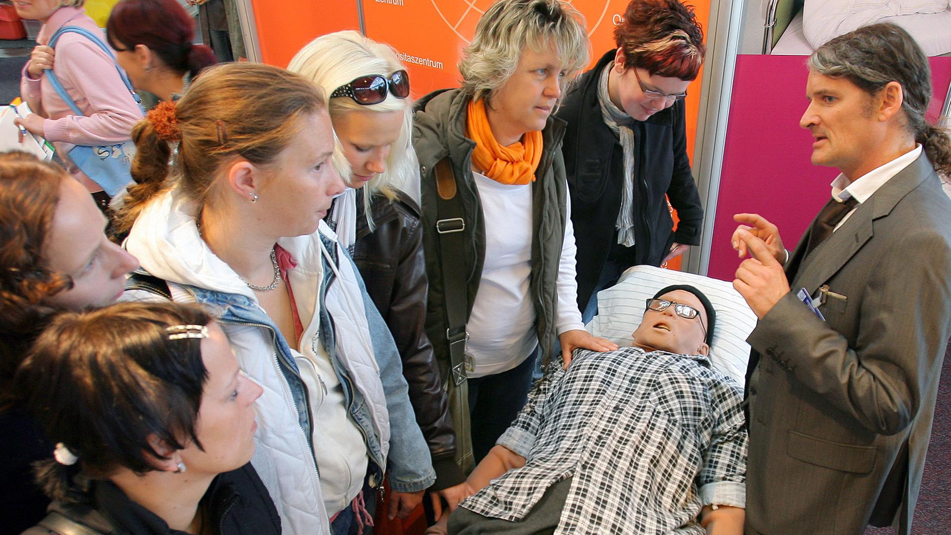 Auf der Landesgesundheitsmesse VitaAktiMed in Rostock demonstriert Oberarzt Gernot Rücker (r) vom Universitätsklinikum Rostock den Besuchern den Patientensimulator "Igor".