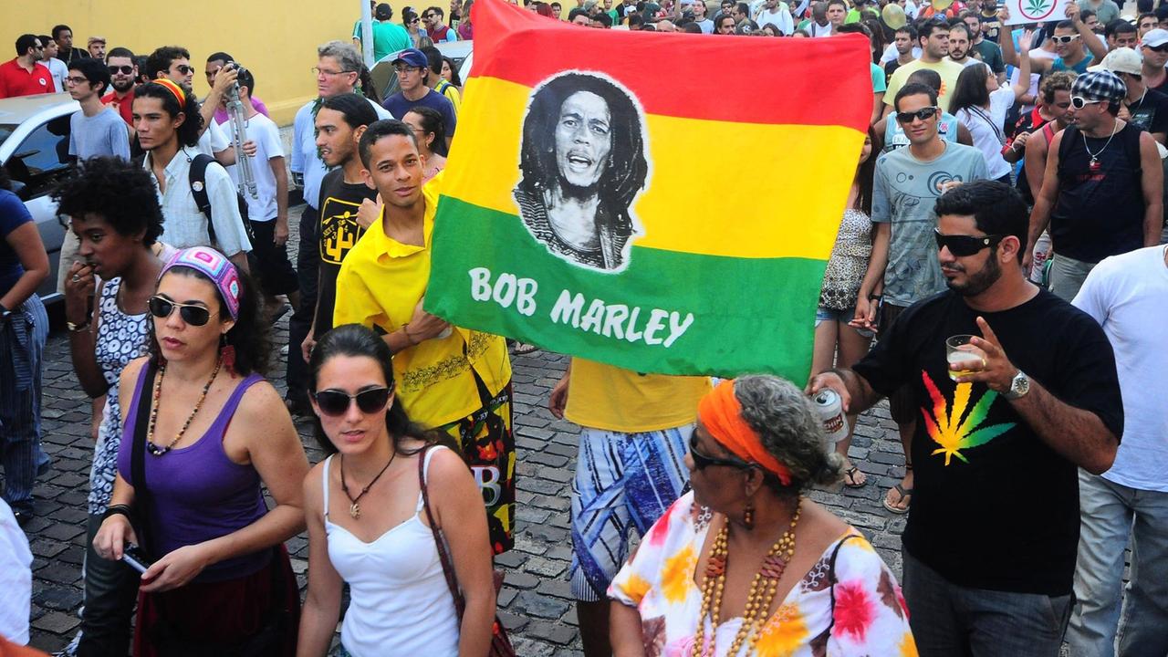 Demonstranten halten eine Fahne mit dem Gesicht des jamaikanischen Sängers Bob Marley hoch. Das ist eine Demonstration für die Legalisierung von Marihuana in Brasilien Demonstranten halten eine Fahne mit dem Gesicht des jamaikanischen Sängers Bob Marley hoch. Das ist eine Demonstration für die Legalisierung von Marihuana in Brasilien