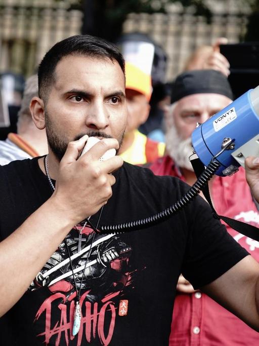 Attila Hildmann spricht vor der russischen Botschaft in Berlin bei einer Demonstration in ein Megaphon