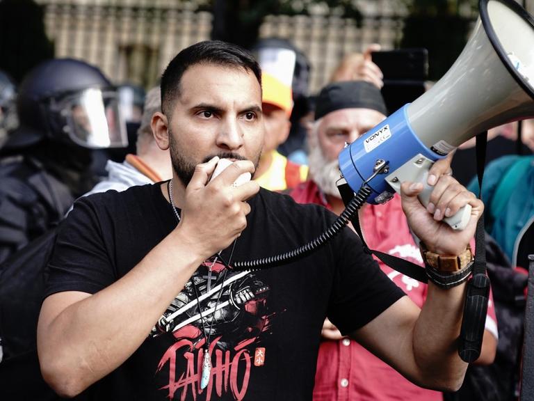 Attila Hildmann spricht vor der russischen Botschaft in Berlin bei einer Demonstration in ein Megaphon