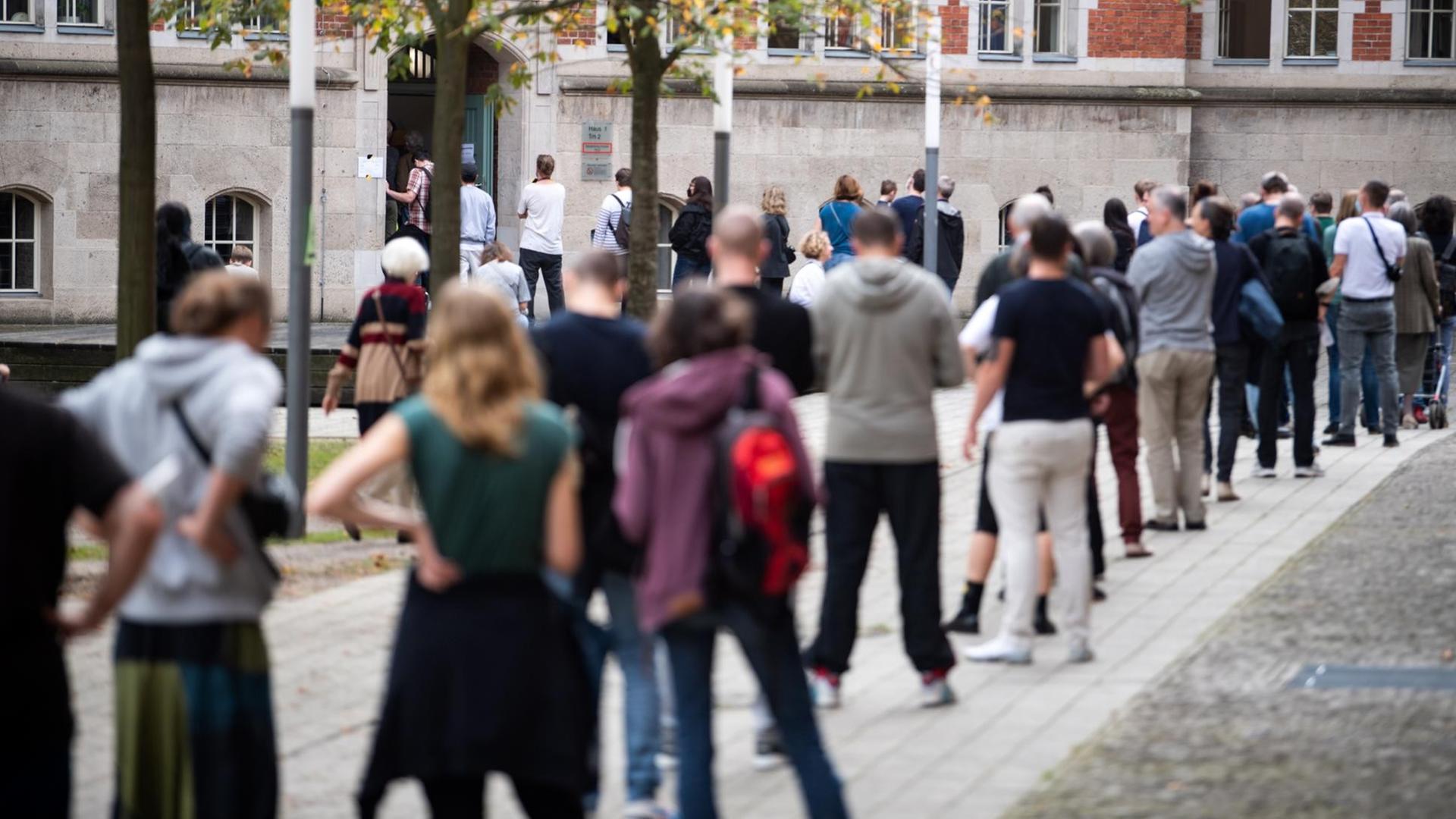 Viele Menschen stehen in einer Schlange vor einem Wahl-Lokal in Berlin. Viele Menschen stehen in einer Schlange vor einem Wahl-Lokal in Berlin.
