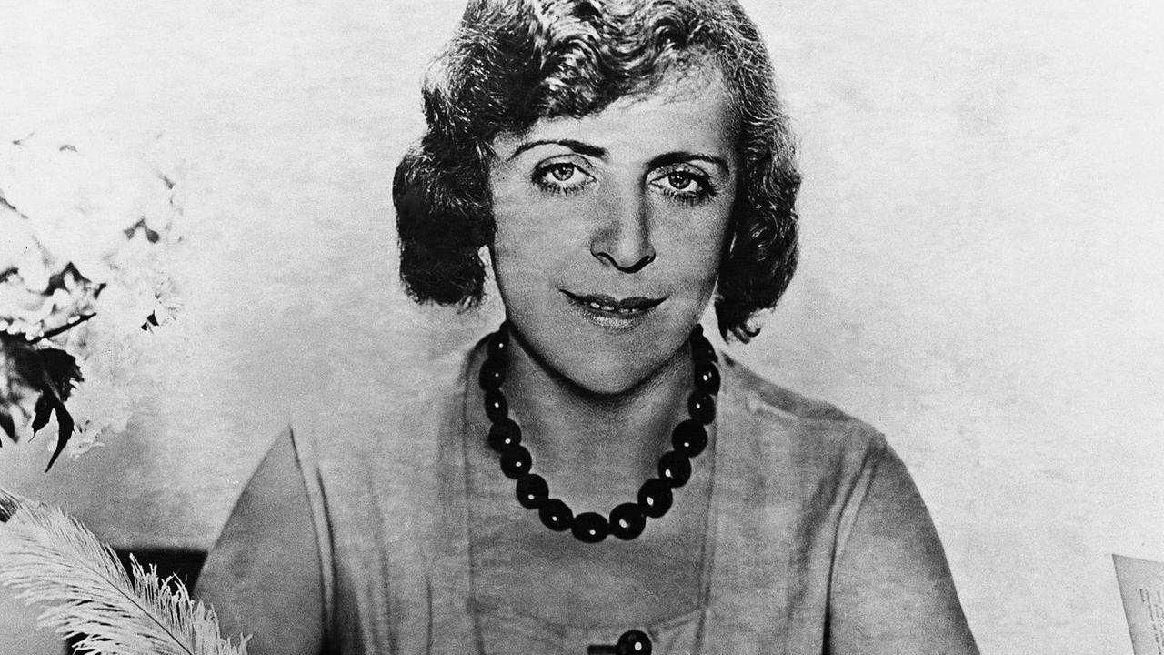 Vicky Baum 1931 in Hollywood, schreibt an einem Tisch mit einer Feder und guckt in Richtung Kamera. Vicky Baum 1931 in Hollywood, schreibt an einem Tisch mit einer Feder und guckt in Richtung Kamera.
