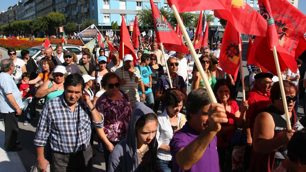 Eine Demonstration gegen die Arbeitslosigkeit am 5. Oktober 2012 in der portugiesischen Stadt Braga. Menschen schwenken Fahnen und halten Transparente. Eine Demonstration gegen die Arbeitslosigkeit am 5. Oktober 2012 in der portugiesischen Stadt Braga. Menschen schwenken Fahnen und halten Transparente.