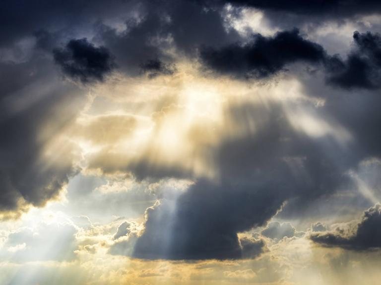 Sonnenstrahlen durchbrechen eine Wolkendecke.