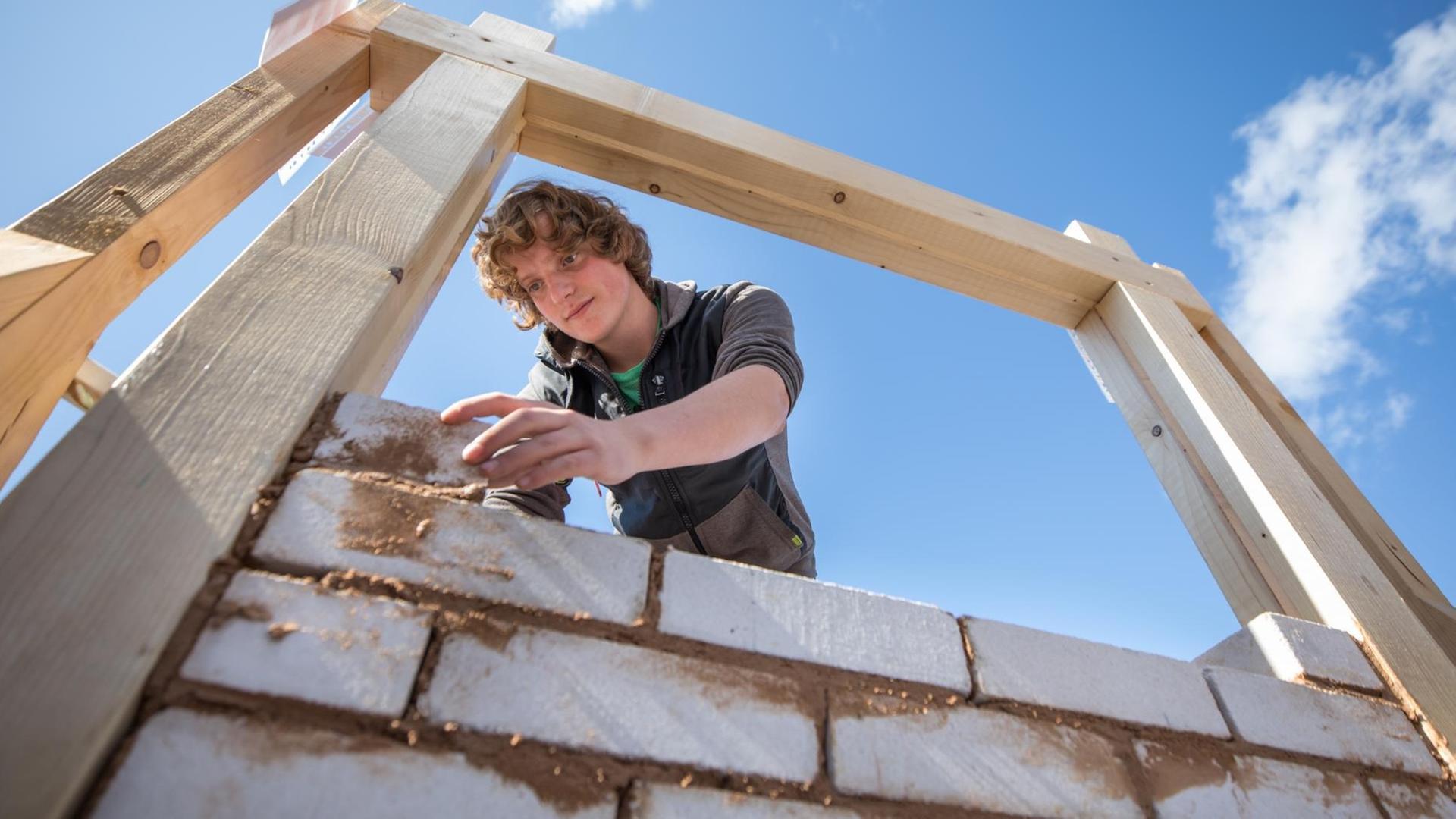 Der Auszubildende Maik Schiefner mauert am 16.09.2017 beim Tag des Handwerks in Suhl (Thüringen) ein Fachwerk aus. Mit 149 Handwerksbetrieben je 10 000 Einwohnern nimmt Südthüringen im Landesvergleich einen Spitzenplatz ein. Foto: Arifoto Ug/Michael Reichel/dpa-Zentralbild/dpa +++ dpa-Bildfunk +++ Der Auszubildende Maik Schiefner mauert am 16.09.2017 beim Tag des Handwerks in Suhl (Thüringen) ein Fachwerk aus. Mit 149 Handwerksbetrieben je 10 000 Einwohnern nimmt Südthüringen im Landesvergleich einen Spitzenplatz ein. Foto: Arifoto Ug/Michael Reichel/dpa-Zentralbild/dpa +++ dpa-Bildfunk +++