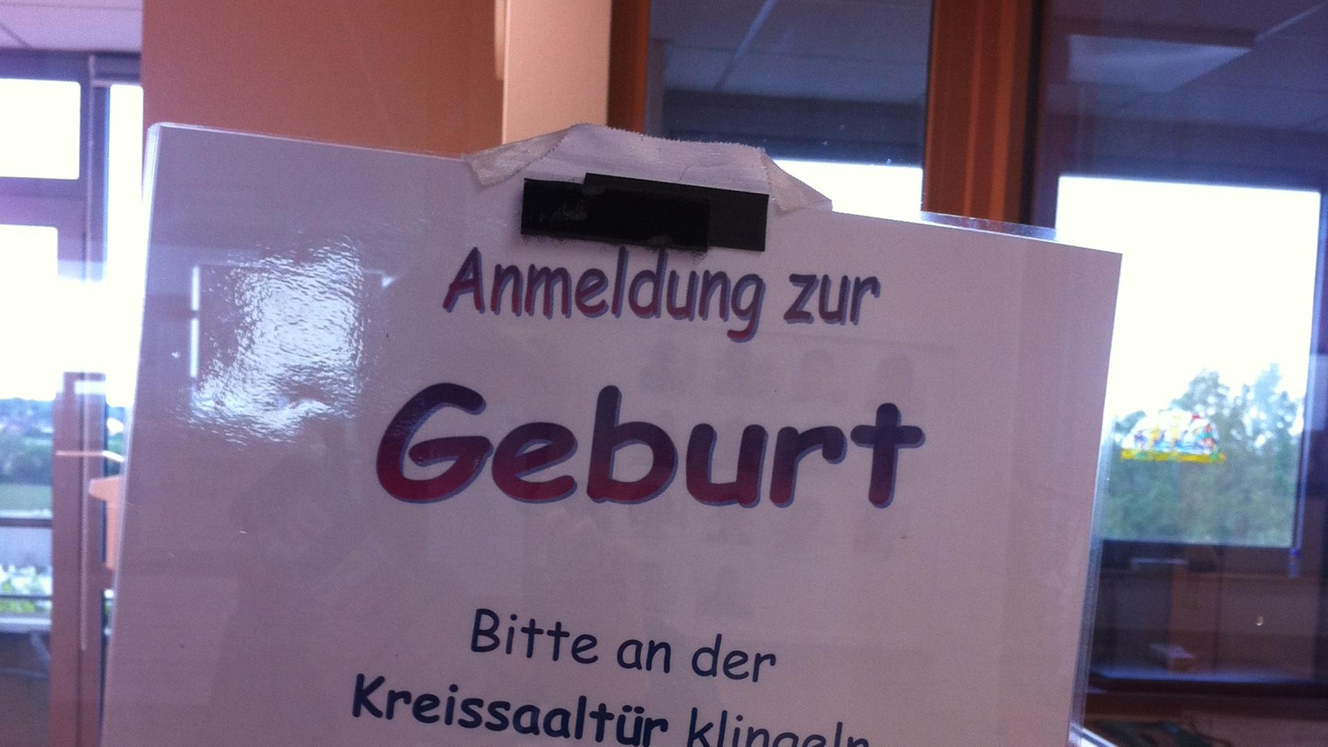 Ein Schild auf dem "Anmeldung zur Geburt Bitte an der Kreissaaltür klingeln" steht. Ein Schild auf dem "Anmeldung zur Geburt Bitte an der Kreissaaltür klingeln" steht.