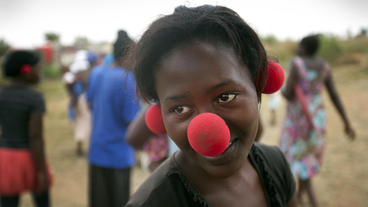 Eine junge Afrikanerin in Johannesburg mit Clownsnase - auf Nase und Ohren -, die sie von der niederländischen Organisation "Africlowns" bekommen hat Eine junge Afrikanerin in Johannesburg mit Clownsnase - auf Nase und Ohren -, die sie von der niederländischen Organisation "Africlowns" bekommen hat