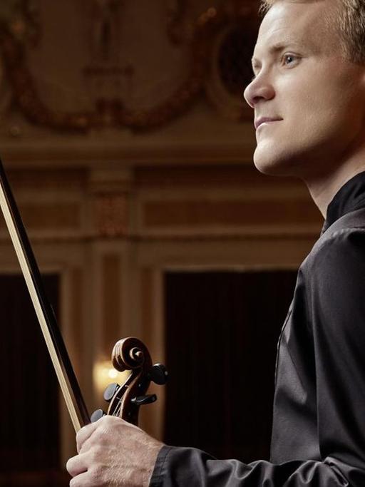 Der Wiener Philharmoniker Christoph Koncz mit Mozarts Geige in einem Konzertsaal.
