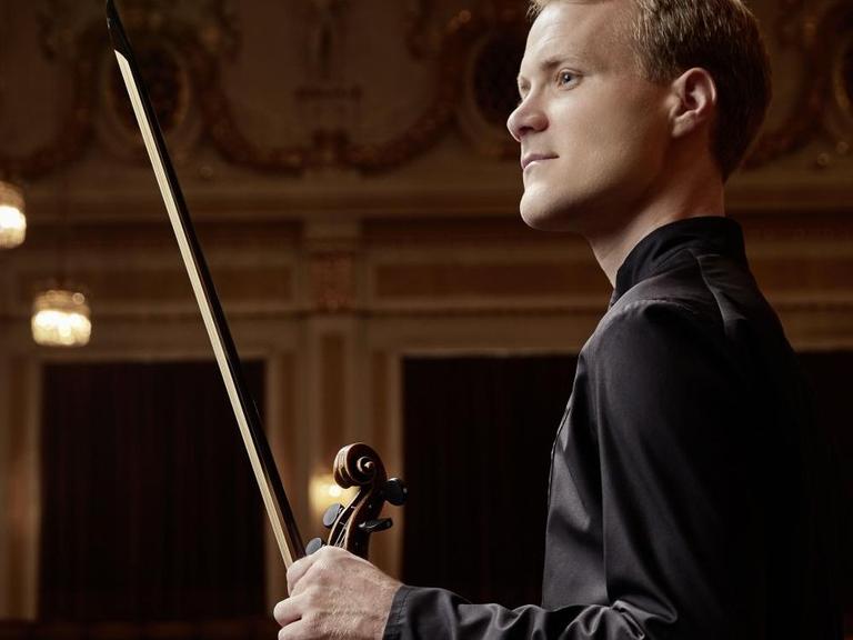 Der Wiener Philharmoniker Christoph Koncz mit Mozarts Geige in einem Konzertsaal.