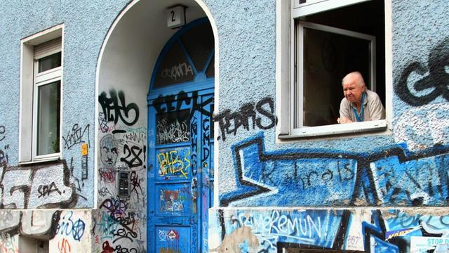 Eine alte Frau blickt aus dem Fenster ihrer Wohnung in Berlin 