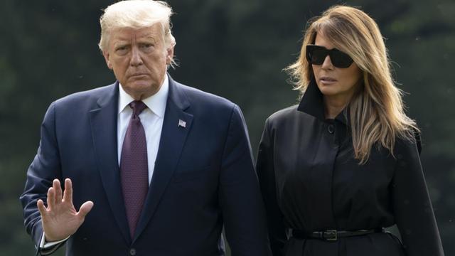 US-Präsident Donald Trump und First Lady Melania Trump laufen über eine Wiese