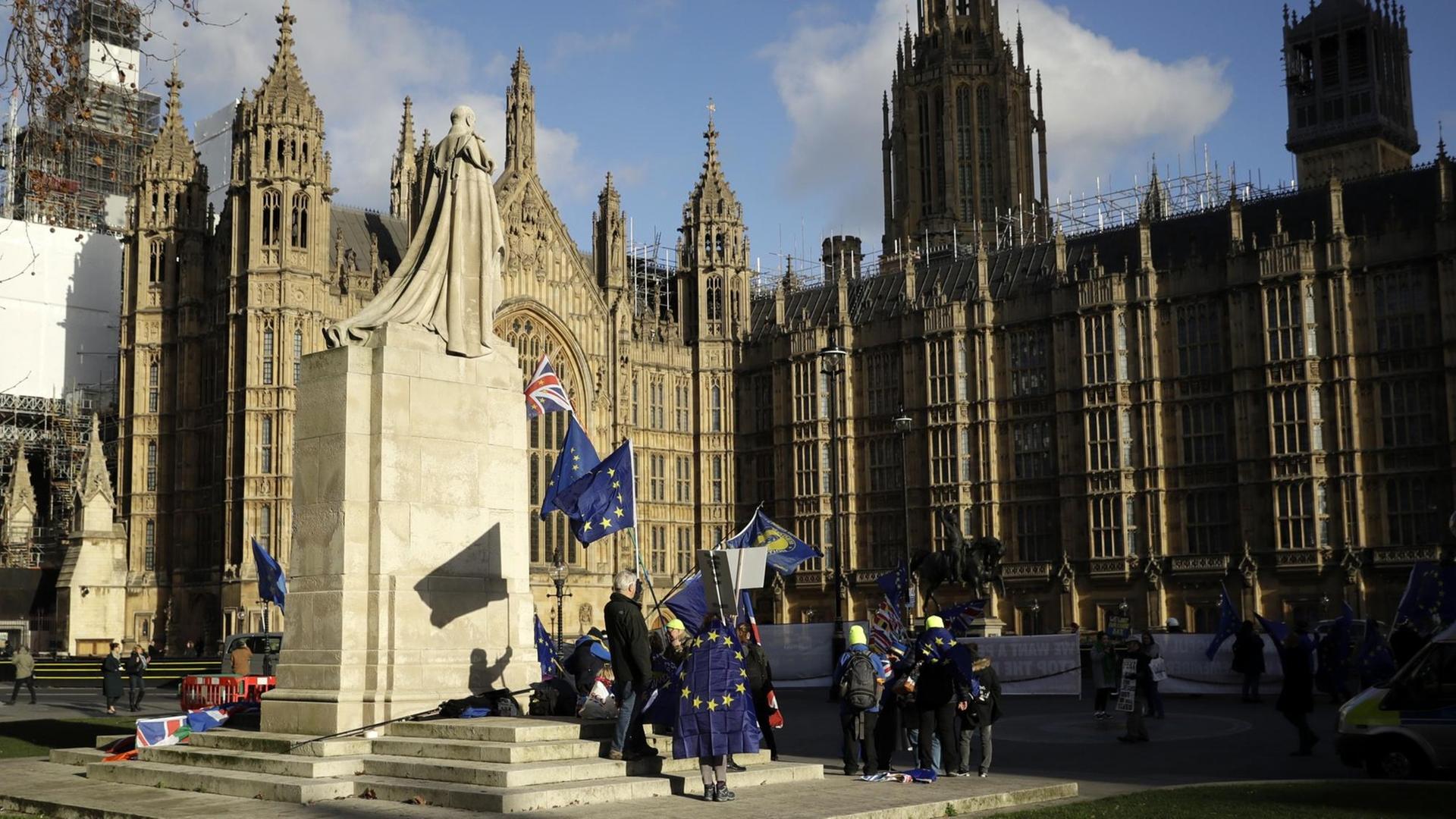Das Foto zeigt die "Houses of Parliament" in London, davor demonstrieren Demonstranten für einen Verbleib Großbritanniens in der EU.