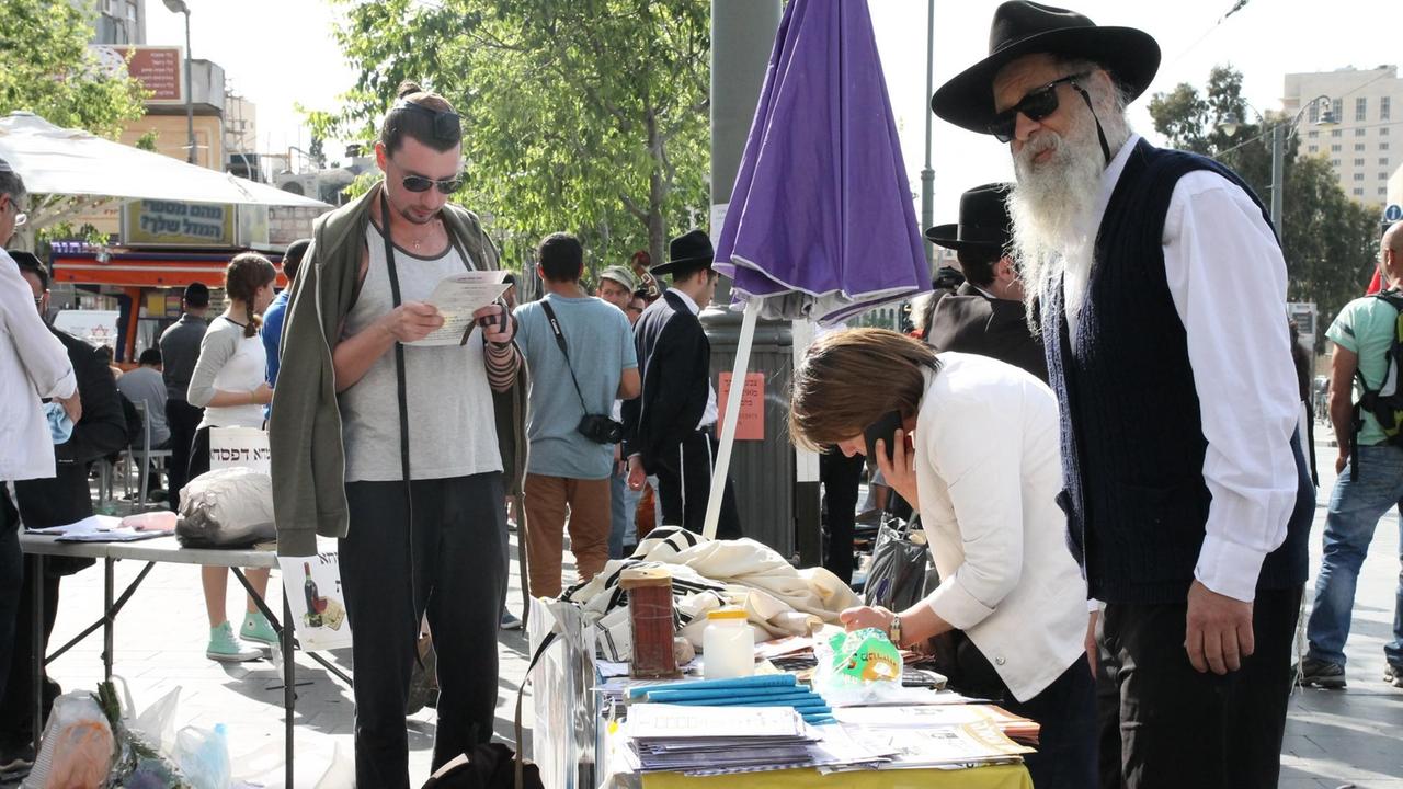 Ein Trödelmarkt in Jerusalem - einige Männer mit schwarzen Hüten und Bärten sind zu sehen zwischen den Touristen. Ein Trödelmarkt in Jerusalem - einige Männer mit schwarzen Hüten und Bärten sind zu sehen zwischen den Touristen.