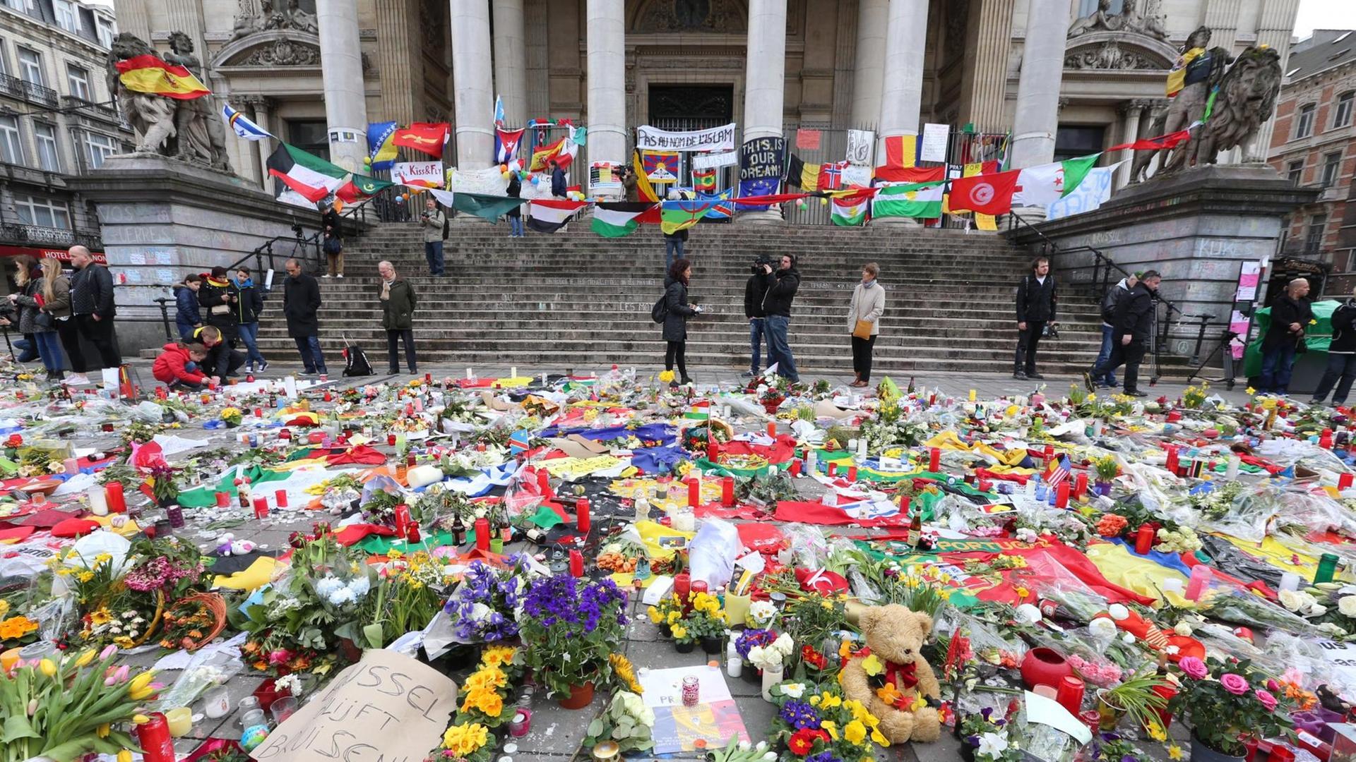 Das Bild zeigt das Börsengebäude, davor Menschen und zahllose Blumen. Das Bild zeigt das Börsengebäude, davor Menschen und zahllose Blumen.