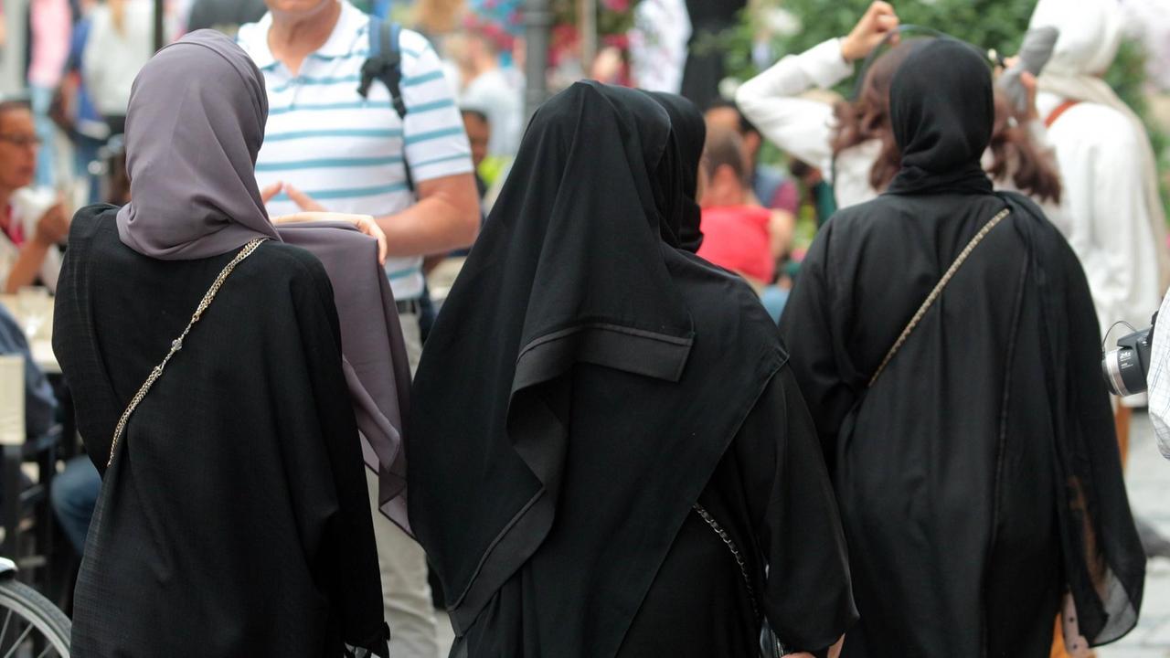 Arabische Muslima mit Burkas spazieren in der Innenstadt von München. Arabische Muslima mit Burkas spazieren in der Innenstadt von München.