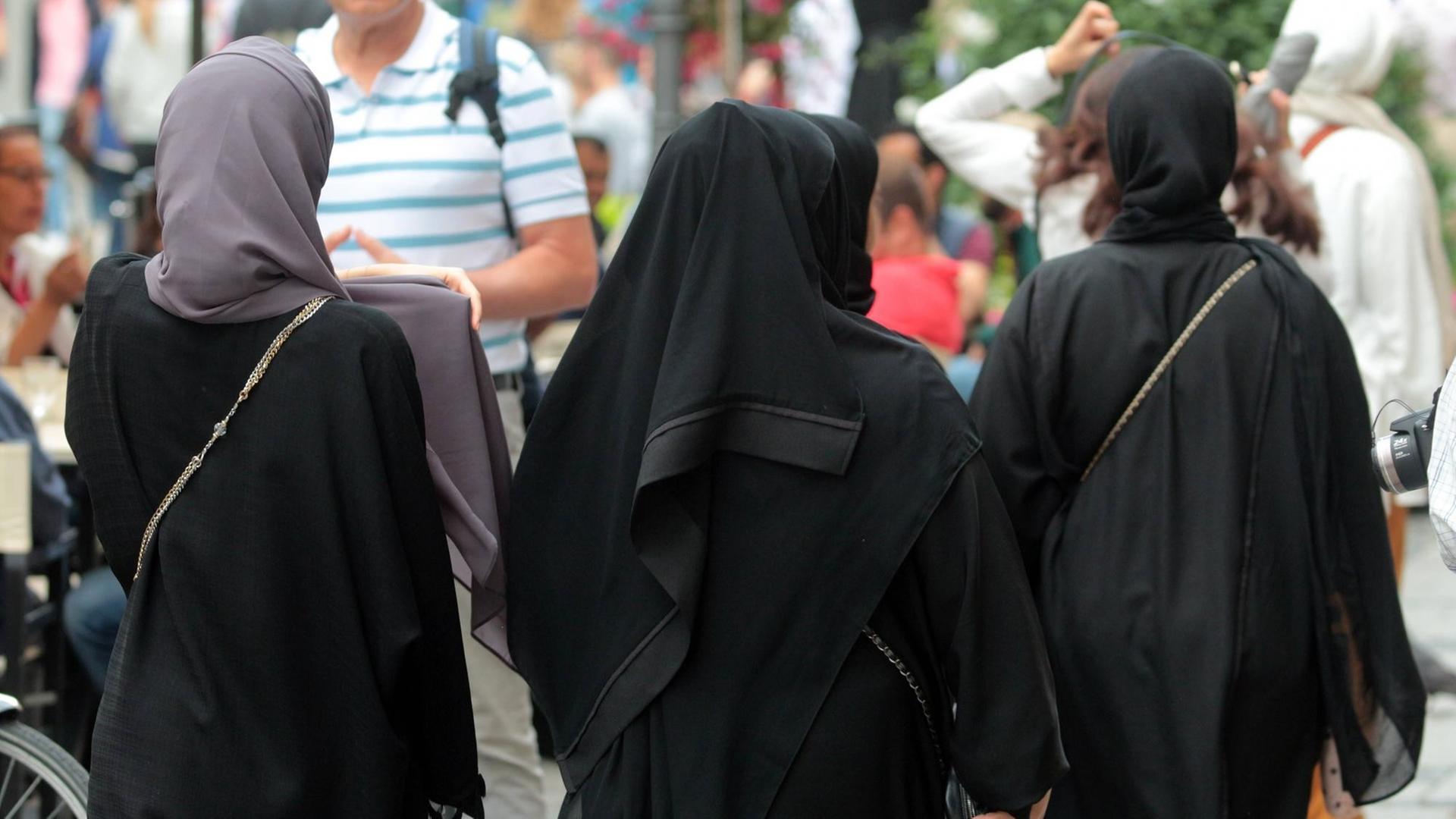 Arabische Muslima mit Burkas spazieren in der Innenstadt von München. Arabische Muslima mit Burkas spazieren in der Innenstadt von München.