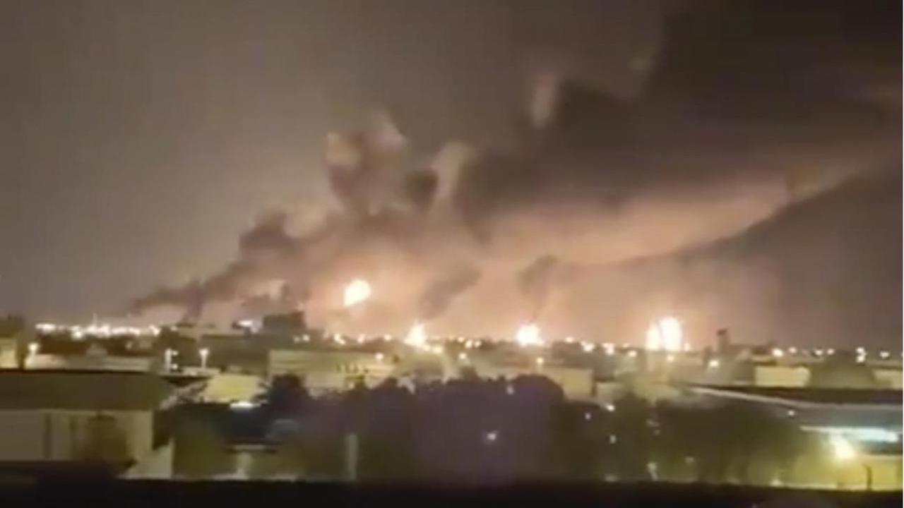 Über einer Ölraffinerie steigt bei Nacht Rauch in den Himmel. Zu sehen sind auch helle Feuerschweife.