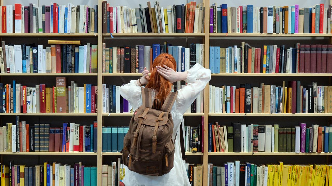 Eine Besucherin steht auf der Leipziger Buchmesse 2017 vor einem Regal mit Büchern. Eine Besucherin steht auf der Leipziger Buchmesse 2017 vor einem Regal mit Büchern.