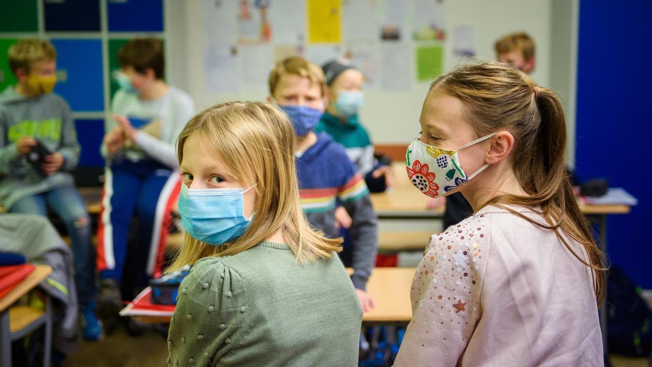 Schülerinnen und Schüler einer sechsten Klasse der Max-Planck-Schule Kiel warten in ihrem Klassenzimmer auf den Unterrichtsbeginn nach den Herbstferien und tragen dabei einen Mund-Nasen-Schutz. Schülerinnen und Schüler einer sechsten Klasse der Max-Planck-Schule Kiel warten in ihrem Klassenzimmer auf den Unterrichtsbeginn nach den Herbstferien und tragen dabei einen Mund-Nasen-Schutz.