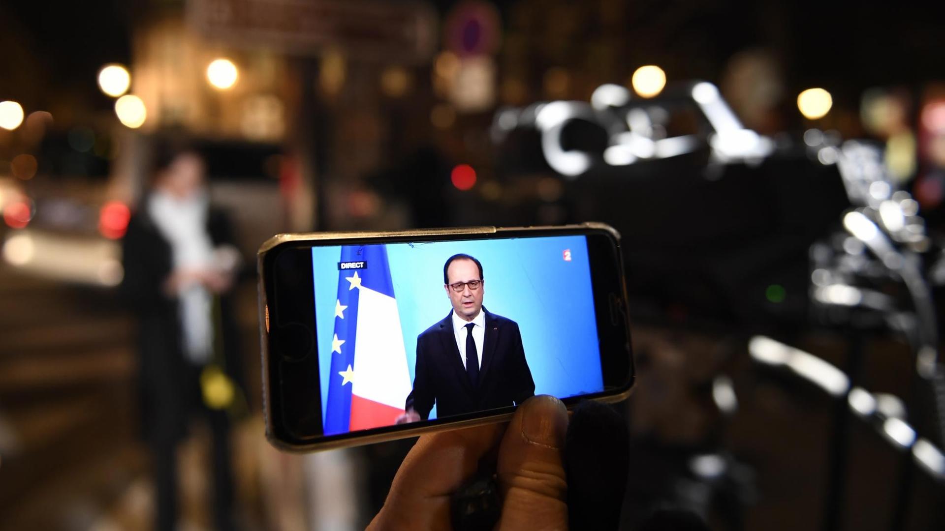 Die Rede von Frankreichs Präsident Hollande ist auf einem Handydisplay zu sehen. Die Rede von Frankreichs Präsident Hollande ist auf einem Handydisplay zu sehen.