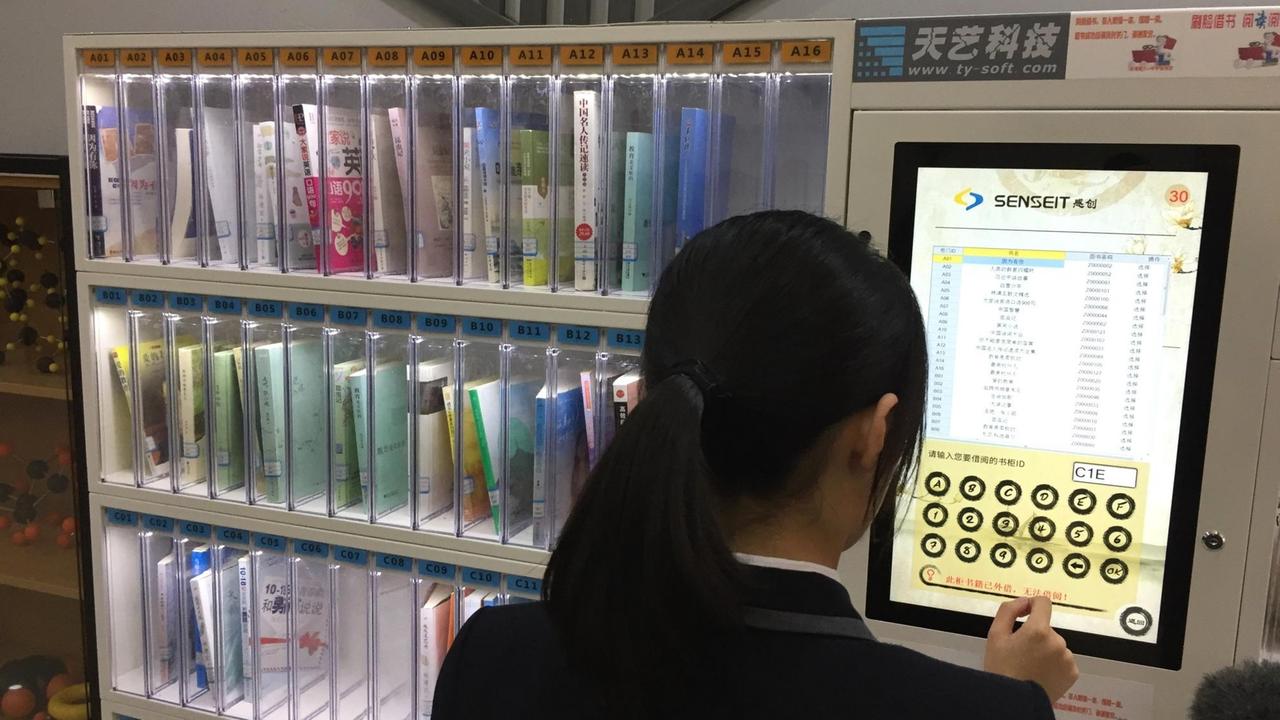 Bücher ausleihen in der Bibliothek der Schule in Hangzhou läuft über Gesichtserkennung. Eine Schülerin hält ihr Gesicht in eine Kamera. Bücher ausleihen in der Bibliothek der Schule in Hangzhou läuft über Gesichtserkennung. Eine Schülerin hält ihr Gesicht in eine Kamera.