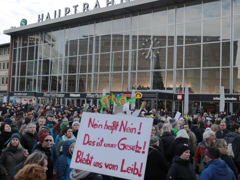 Hunderte Menschen haben sich in Köln vor dem Hauptbahnhof versammelt. Sie tragen Plakate mit Aufschriften wie "Nein heißt nein! Das ist unser Gesetz!"