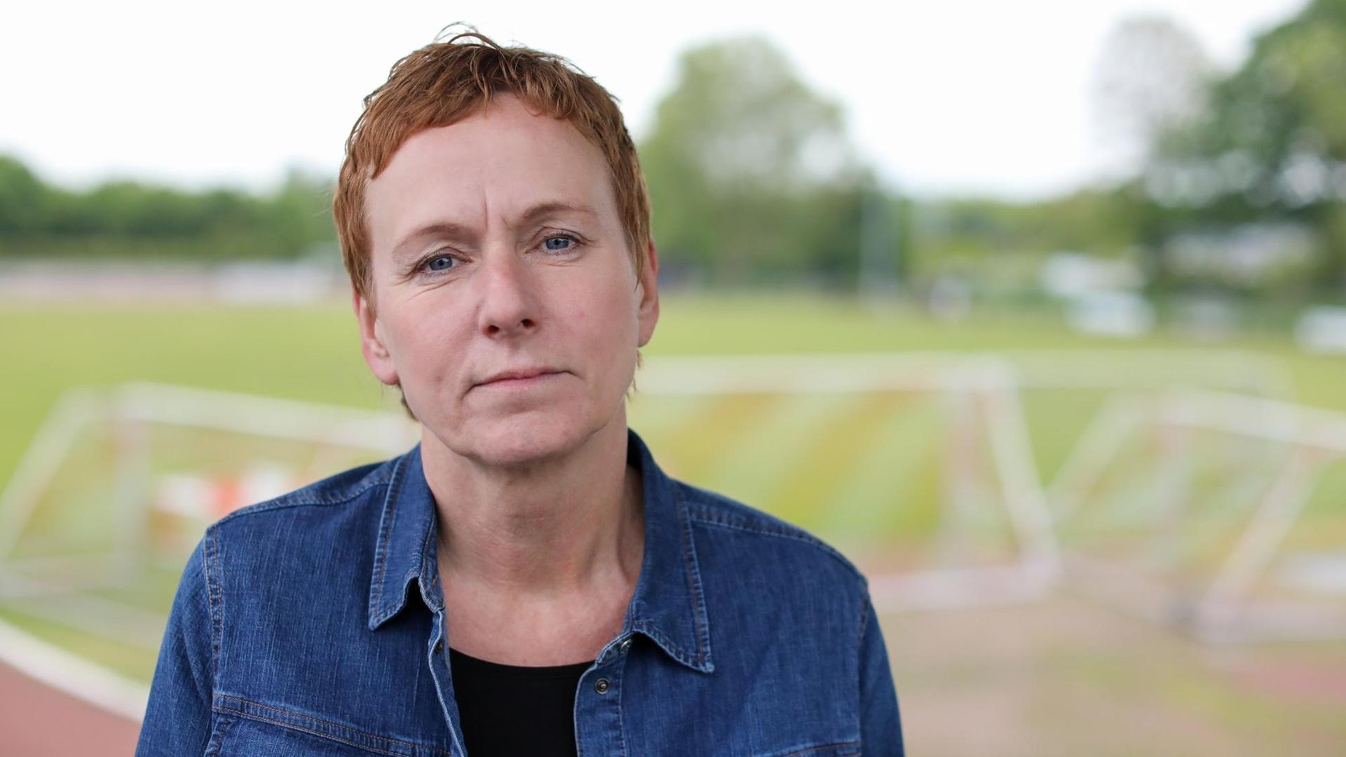 Ute Groth, Vorsitzende des DJK Tusa 06 Düsseldorf, steht am Fußballplatz des Vereins. Ute Groth, Vorsitzende des DJK Tusa 06 Düsseldorf, steht am Fußballplatz des Vereins.