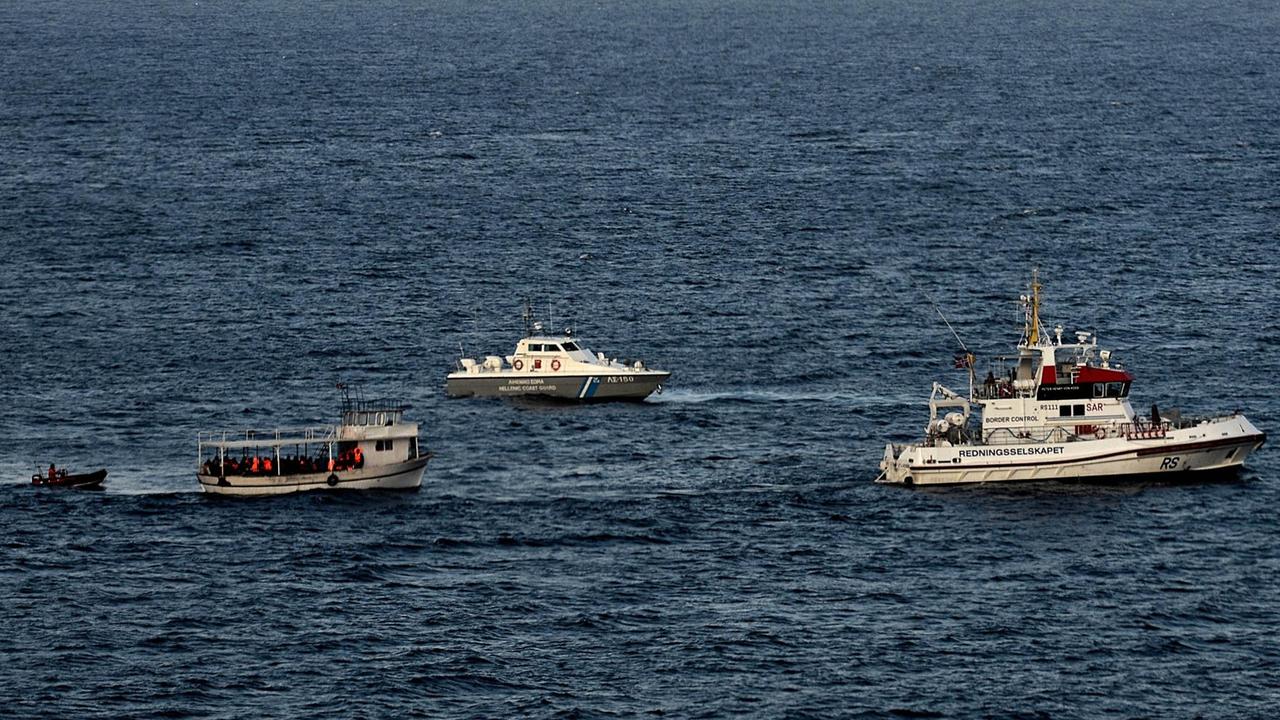Ein Flüchtlingsboot an der griechischen Küste vor Lesbos wird von der griechischen Küstenwache und Frontex eskortiert. Ein Flüchtlingsboot an der griechischen Küste vor Lesbos wird von der griechischen Küstenwache und Frontex eskortiert.