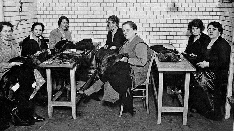 Näherinnen des Berliner Modemachers Leopold Seligmann sitzen an ihren Arbeitstischen.

