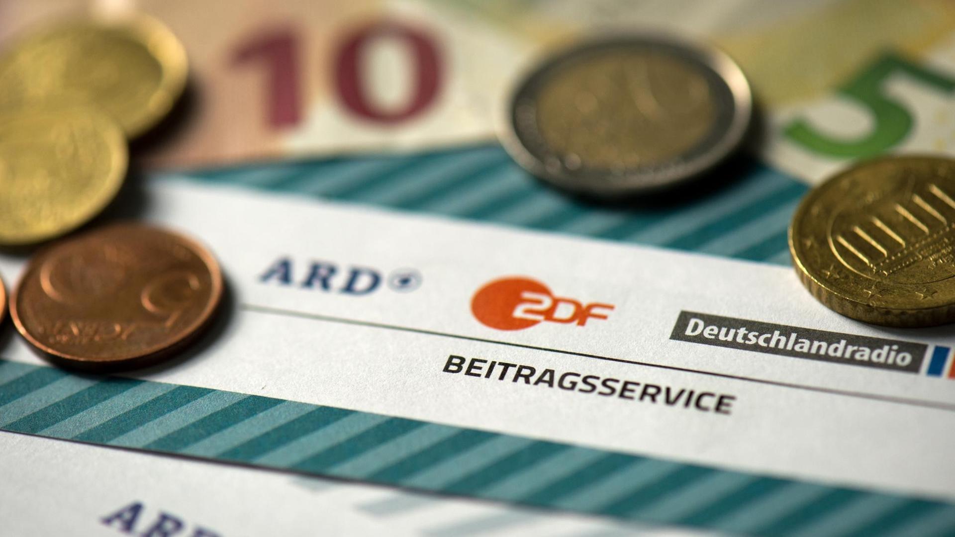 Münzgeld liegt auf Formularen für den Rundfunkbeitrag von ARD, ZDF und Deutschlandradio Münzgeld liegt auf Formularen für den Rundfunkbeitrag von ARD, ZDF und Deutschlandradio