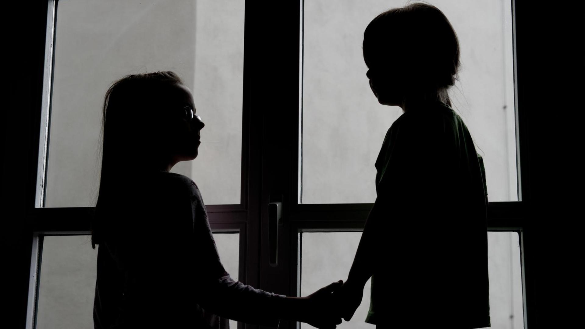 Die Silhouette zweier Kinder in einer Tagespflegeeinrichtung Die Silhouette zweier Kinder in einer Tagespflegeeinrichtung