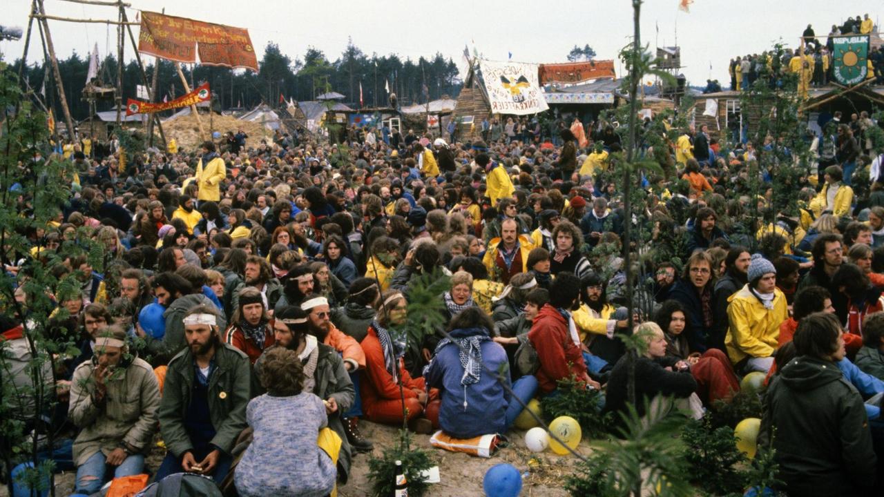 Protestanten sitzen auf dem Boden vor dem Hüttendorf der "Republik Freies Wendland". Protestanten sitzen auf dem Boden vor dem Hüttendorf der "Republik Freies Wendland".