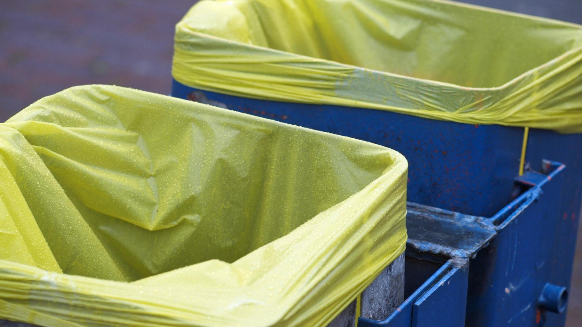 Blaue Mülltonnen mit gelben Säcken