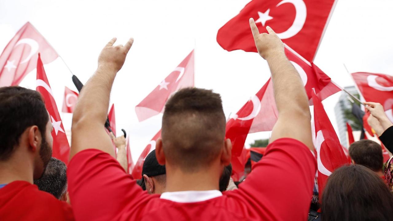 Ein Teilnehmer der Erdogan-Großkundgebung anlässlich des gescheiterten Putschversuchs in der Türkei mit ca. 20.000 Erdogan-Anhängern in der Deutzer Werft in Köln reißt die Arme hoch und zeigt den Gruß der türkisch-nationalistischen Organisation der "Grauen Wölfe"