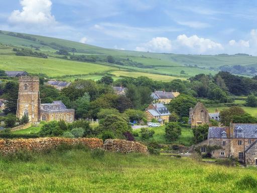Blick auf das Dorf Abbotsbury mit der Pfarrkirche St. Nicholas in Dorset im ländlichen England