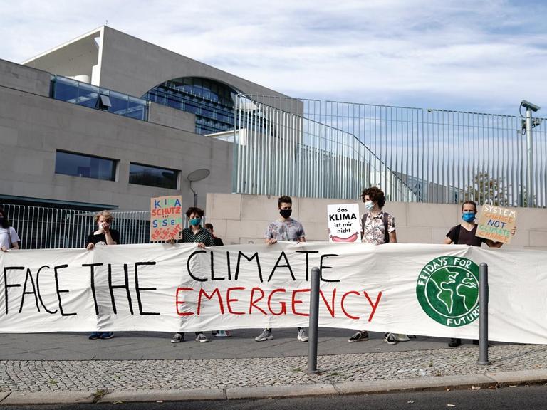 Klimaaktivisten der Fridays for Future Bewegung stehen am Morgen vor dem Bundeskanzleramt mit dem Banner "Face the Climate Emergency". Die Bundeskanzlerin empfängt die führenden Aktivistinnen der Klimaschutz-Bewegung Thunberg und Neubauer im Kanzleramt zum Gespräch.