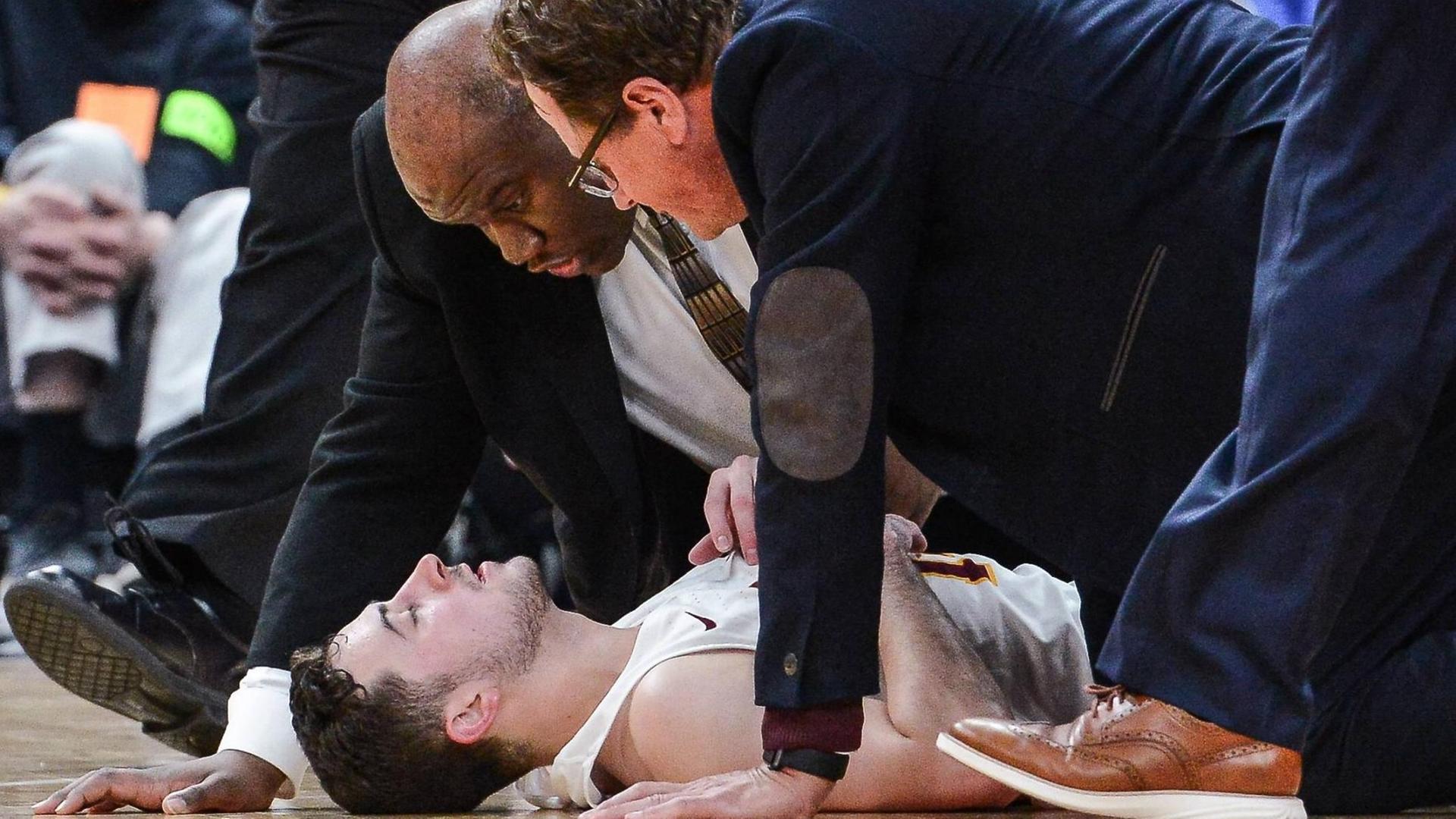 Die Trainer des College-Basketballer Ben Richardson von der Loyola University Chicago reden vehement auf ihren verletzten Schützling ein. Die Trainer des College-Basketballer Ben Richardson von der Loyola University Chicago reden vehement auf ihren verletzten Schützling ein.