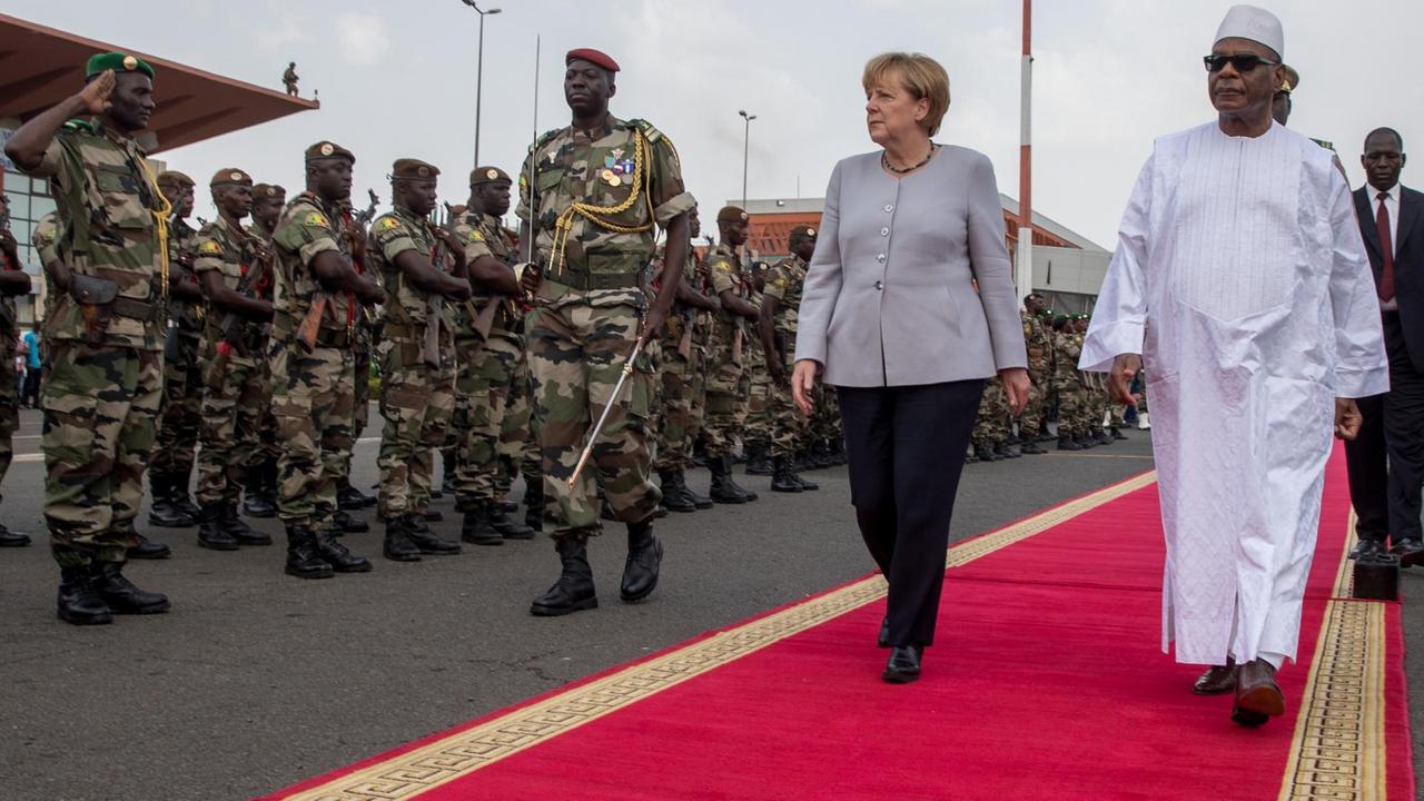 Bundeskanzlerin Angela Merkel und Malis Staatspräsident Ibrahim Boubacar Keita schreiten in Mali eine Militärformation ab.