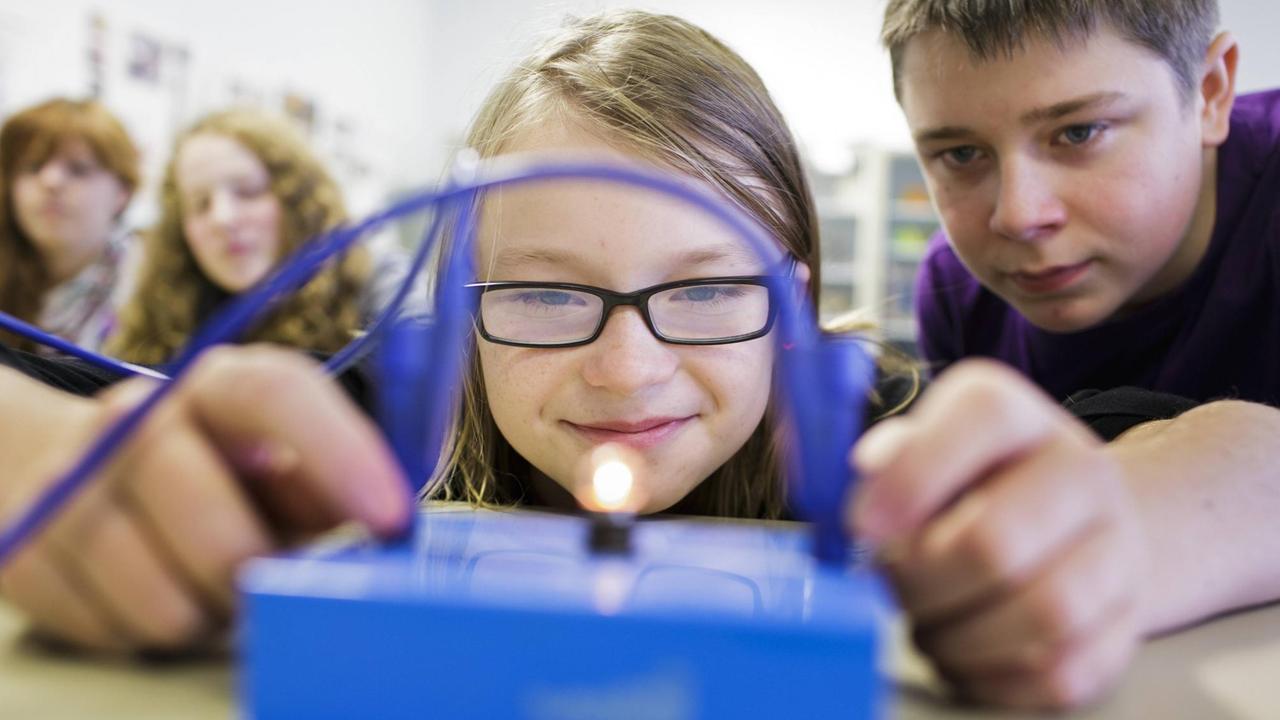 Schülerinnen und Schüler in einer Schulklasse der Heinrich-Mann-Schule in Berlin Neukölln machen ein physikalisches Experiment. Schülerinnen und Schüler in einer Schulklasse der Heinrich-Mann-Schule in Berlin Neukölln machen ein physikalisches Experiment.