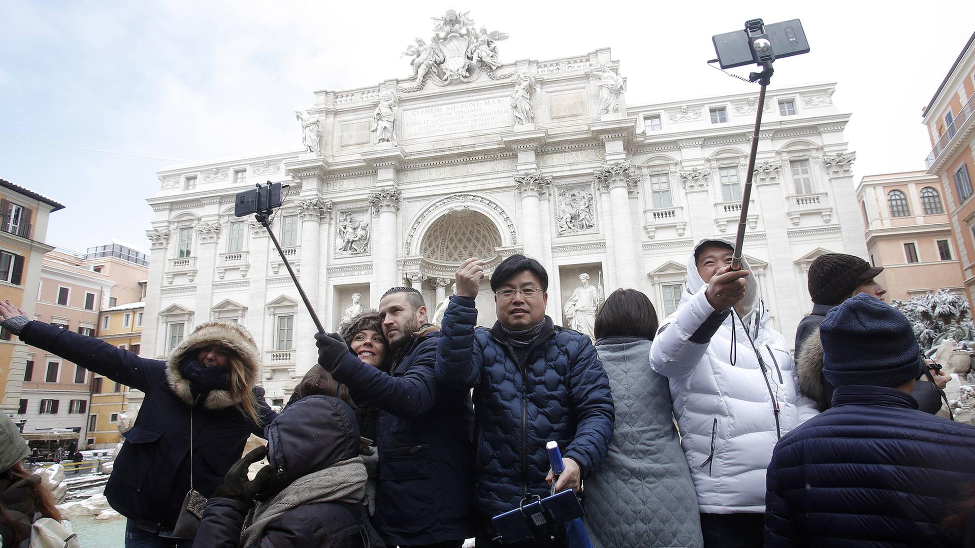 Touristen machen vor dem Trevi-Brunnen in Rom Selfies. Touristen machen vor dem Trevi-Brunnen in Rom Selfies.
